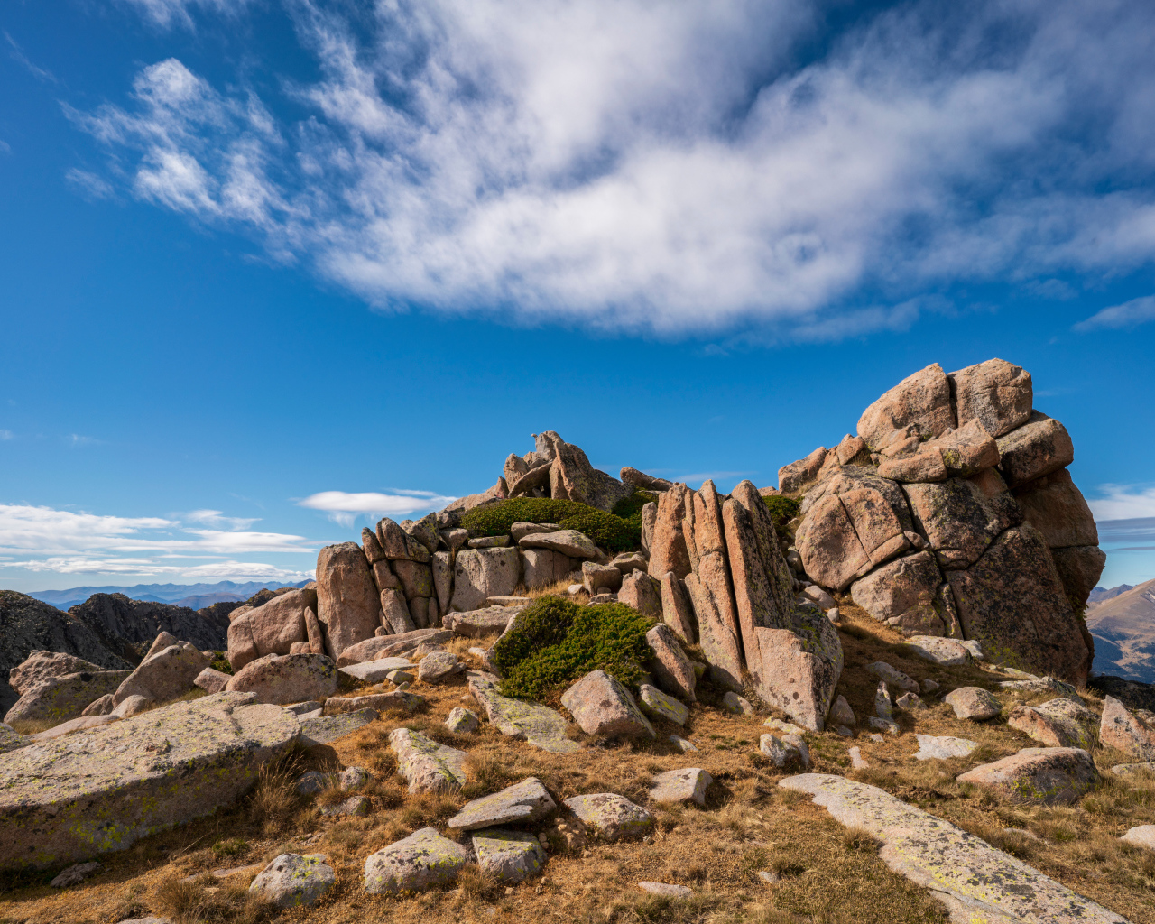 Каменные горы под голубым небом с белыми облаками 