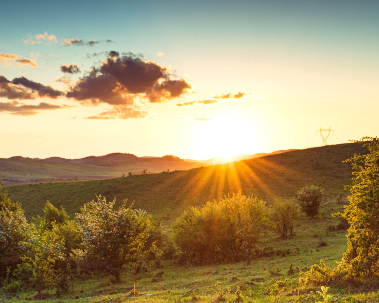Яркое летнее солнце встает из-за гор 