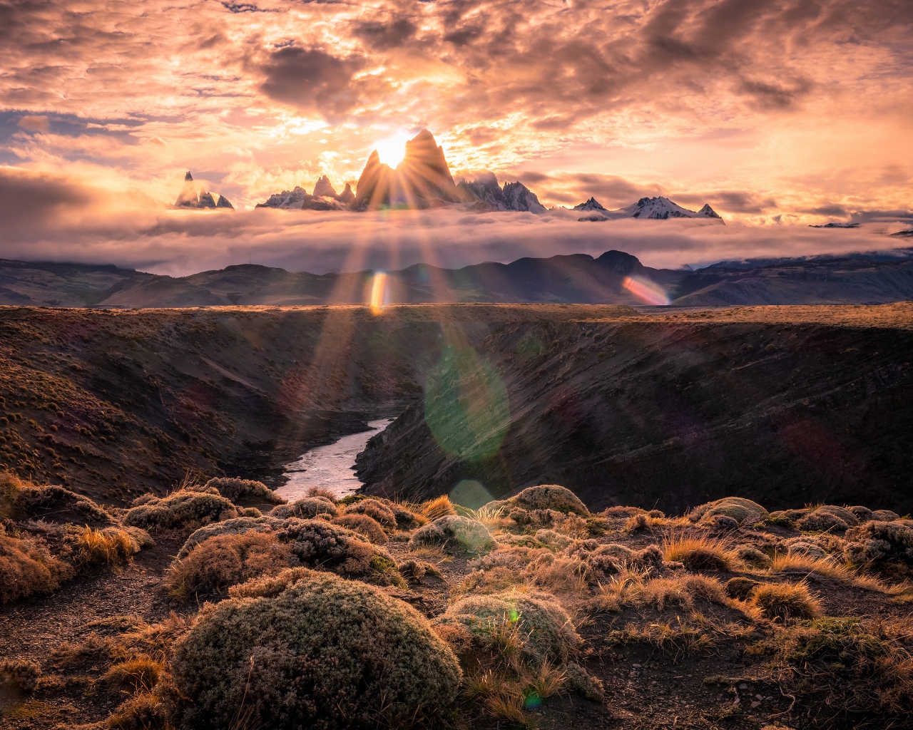 Лучи яркого солнца пробиваются сквозь вершину горы на рассвете 