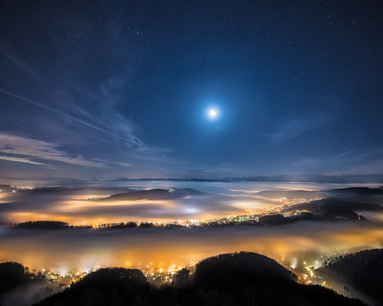 Вид с горы на покрытый туманом ночной город 