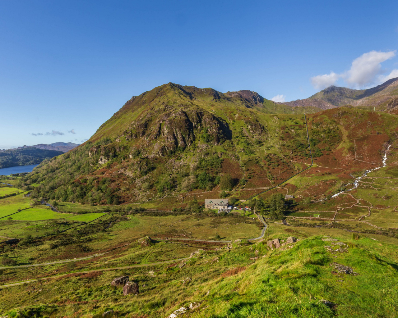 Вид на покрытую зеленью гору под голубым небом