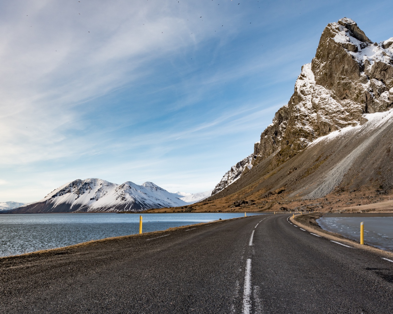 Асфальтовая дорога ведет в горы под голубым небом