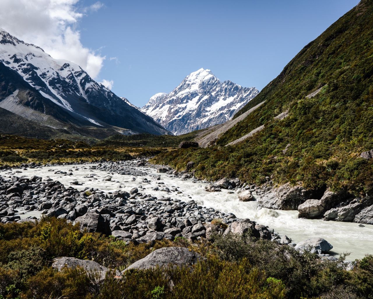 Заледеневшая река на фоне заснеженных гор 