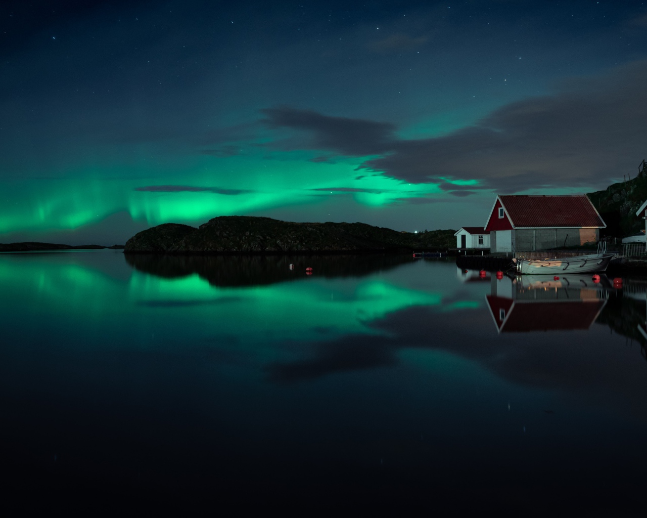 Дома на берегу озера на фоне полярного сияния 