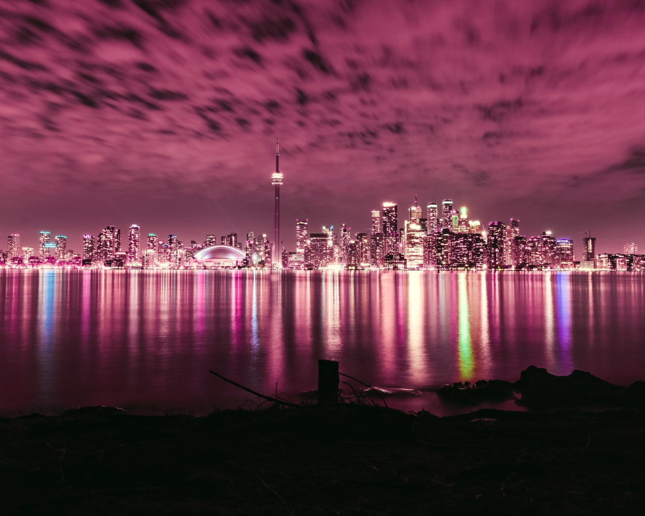 Ночной город под голубым небом отражается в воде 