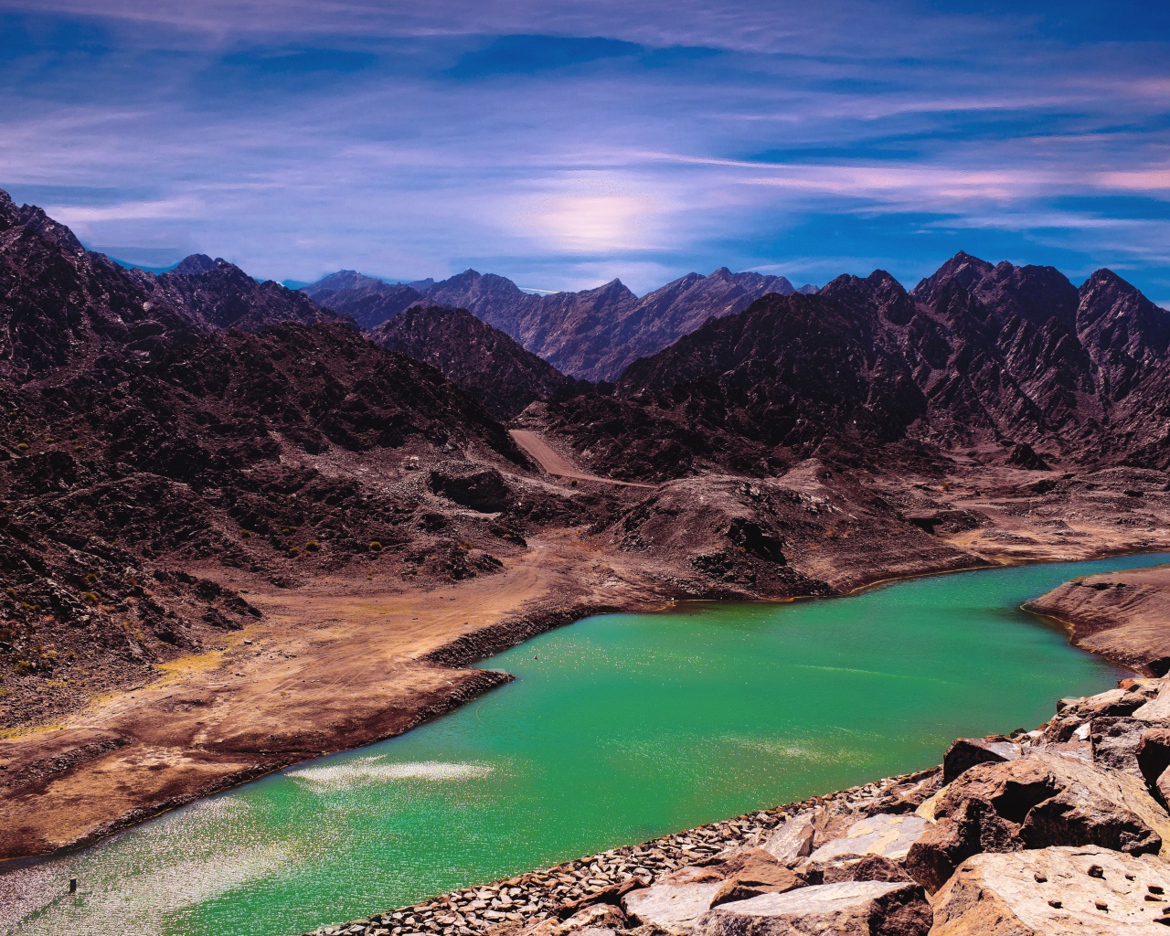 Река между высоких гор под голубым небом 