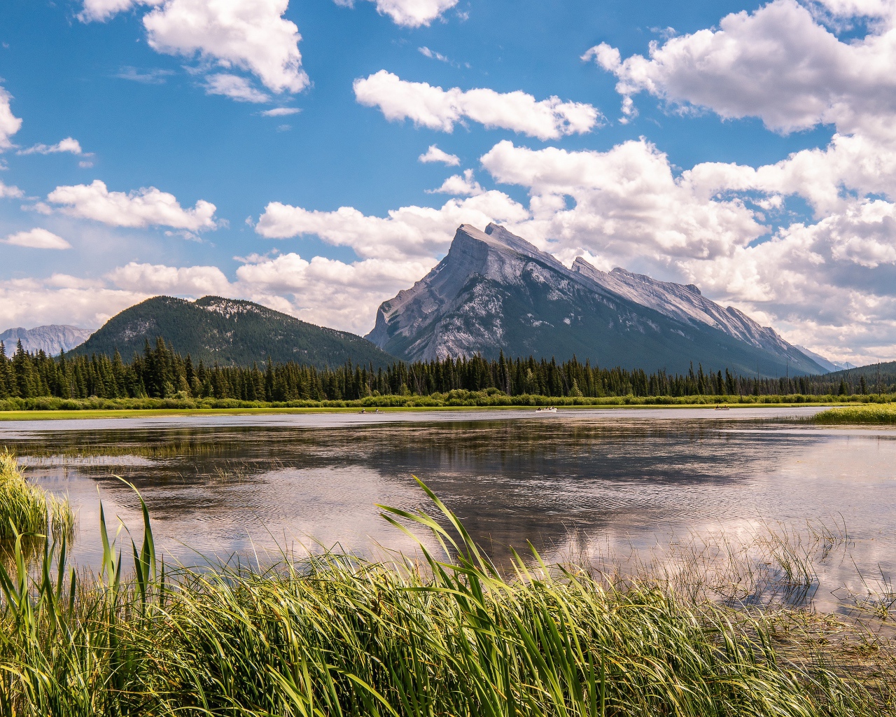 Красивое горное озеро под голубым небом с белыми облаками