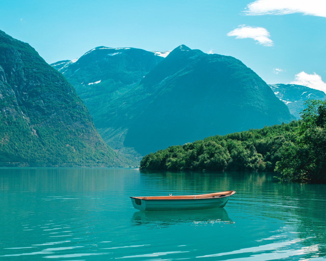 Лодка на голубой воде озера в горах 