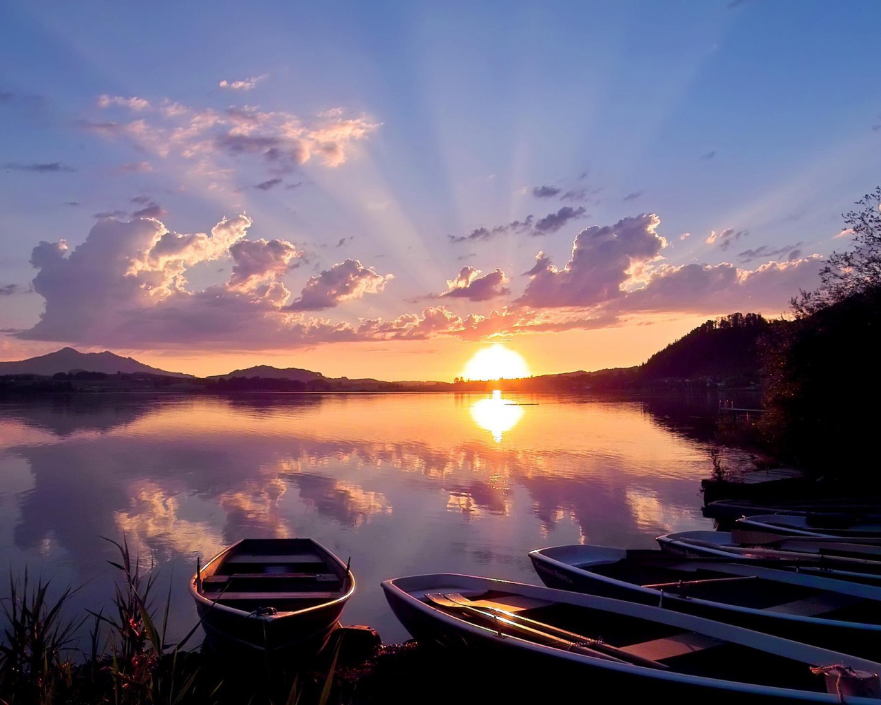 Лодки на берегу озера на закате солнца