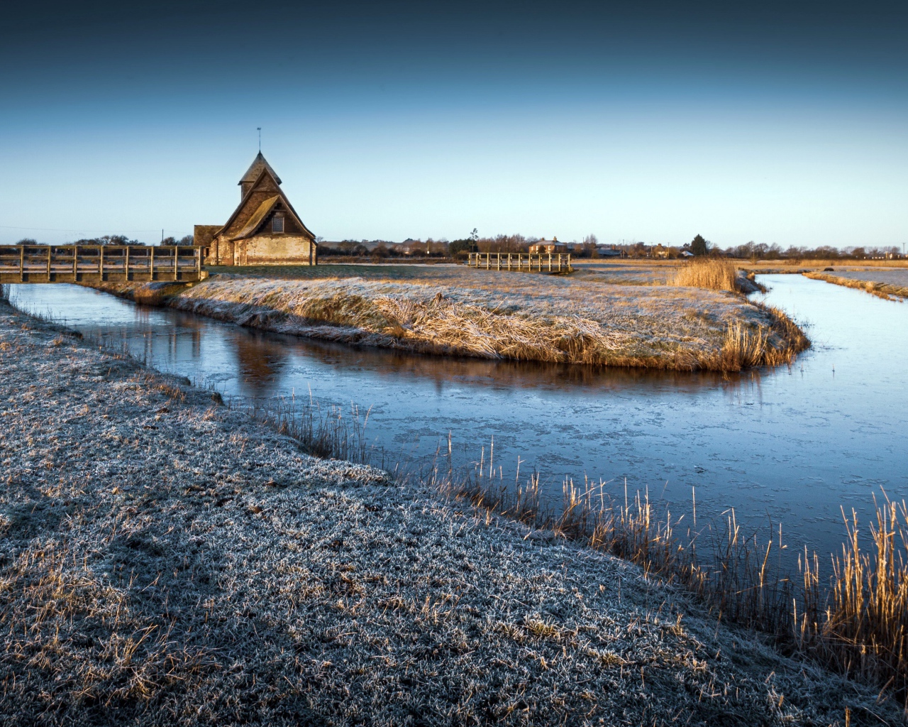 Иней покрывает землю холодным утром у реки