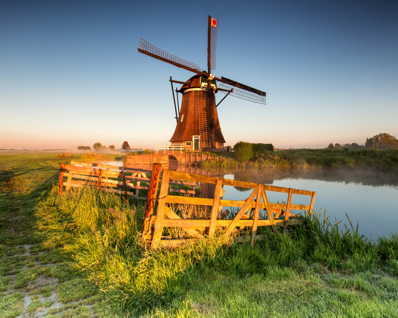 Старая мельница на берегу озера на ферме 