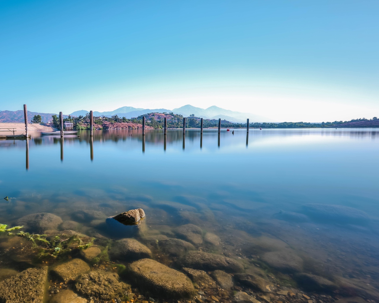 Камни в озере на фоне голубого неба