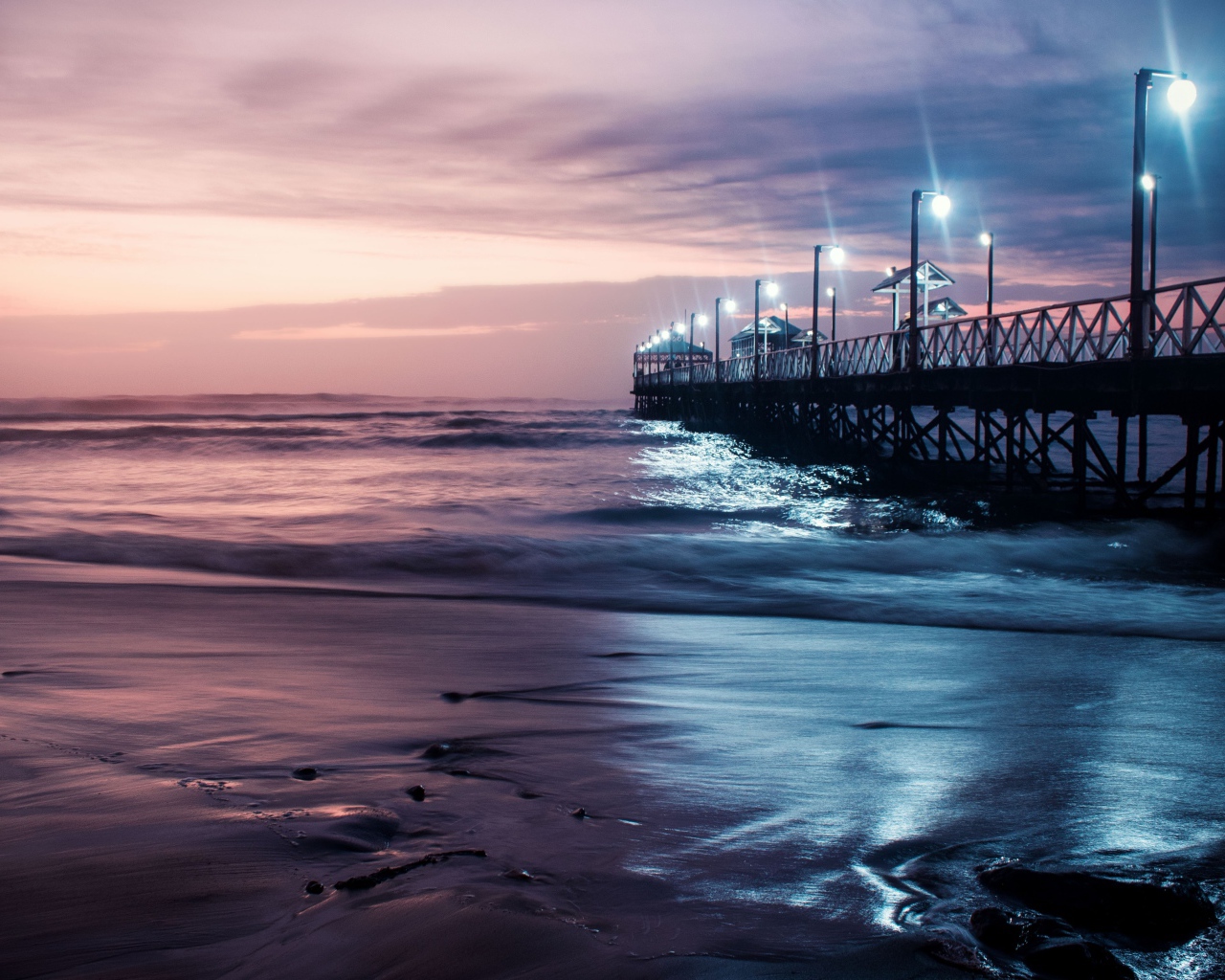 Вид на мост в океане с включенными фонарями ночью