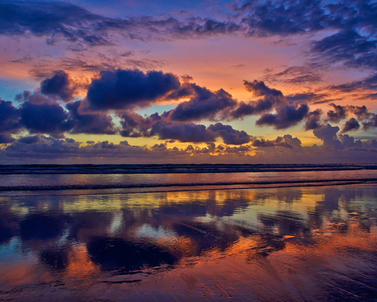 Черные тучи отражаются в морской воде на закате