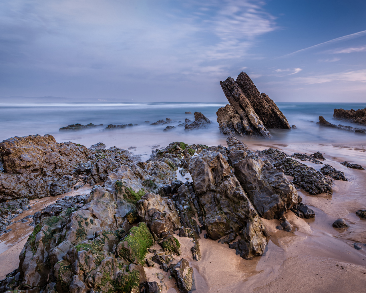 Туман над холодным утренним морем с камнями на берегу 