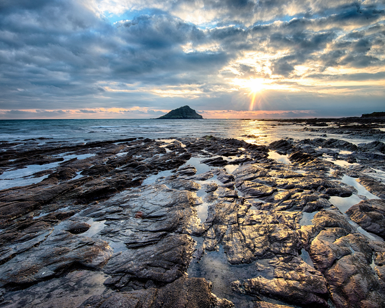 Каменный берег океана в лучах солнца