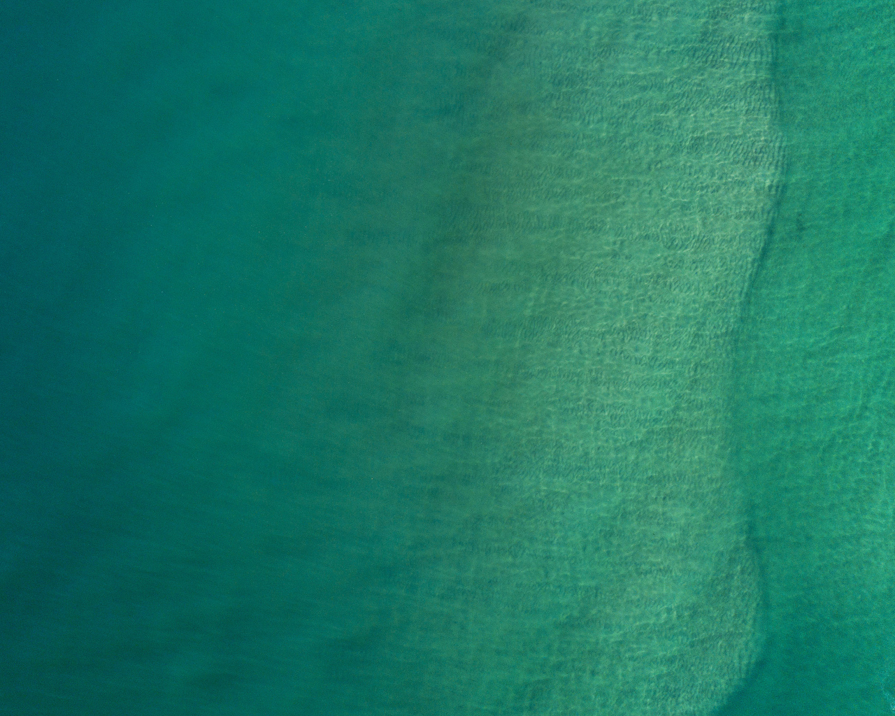 Вид сверху на спокойную голубую гладь океана