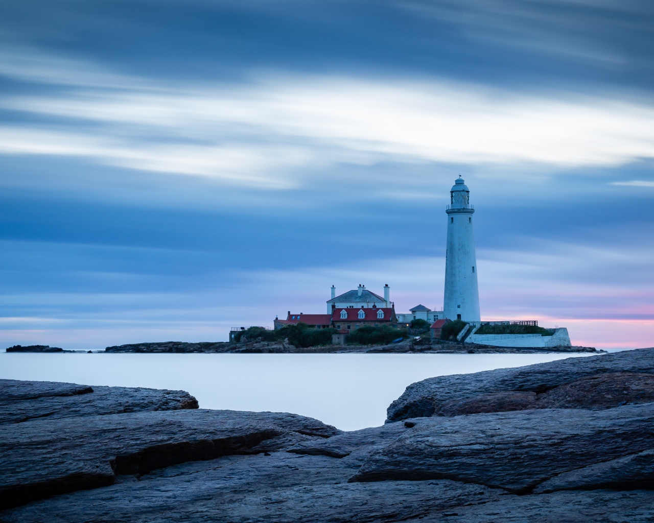 Вид с каменного берега на маяк в море 