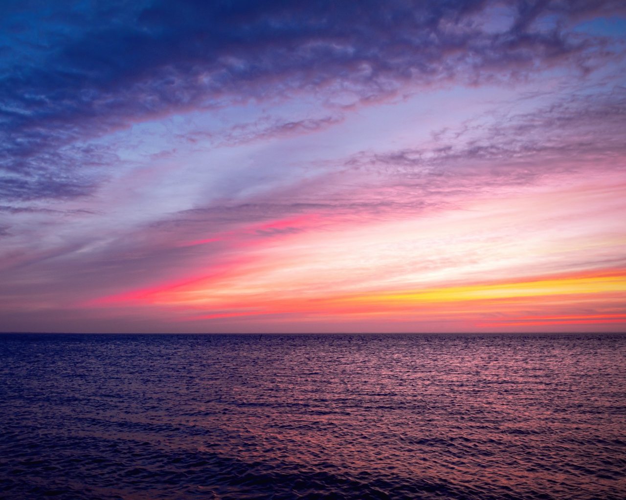 Красивый розовый закат в небе над тихим морем