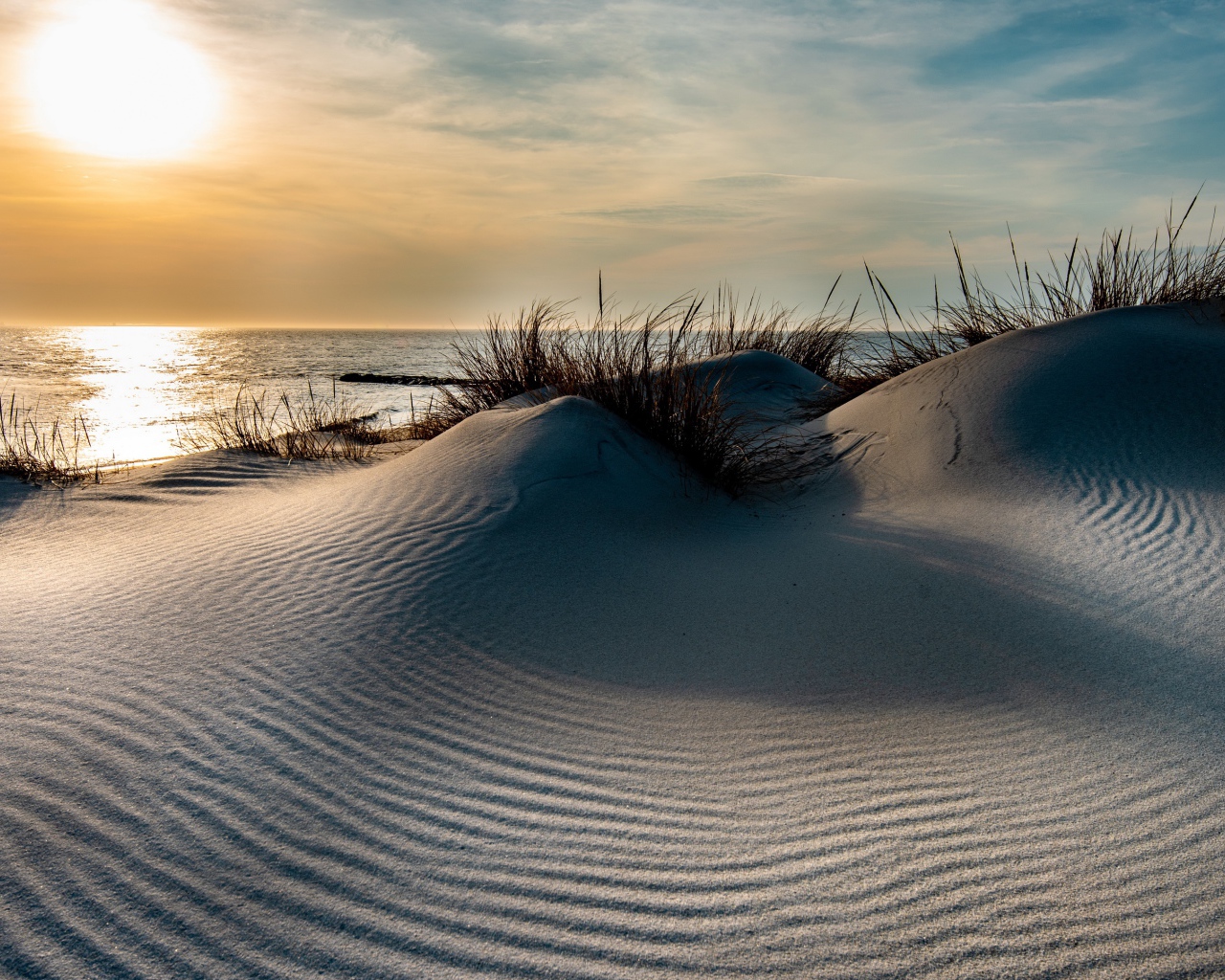 Горячий песок на берегу моря на закате 