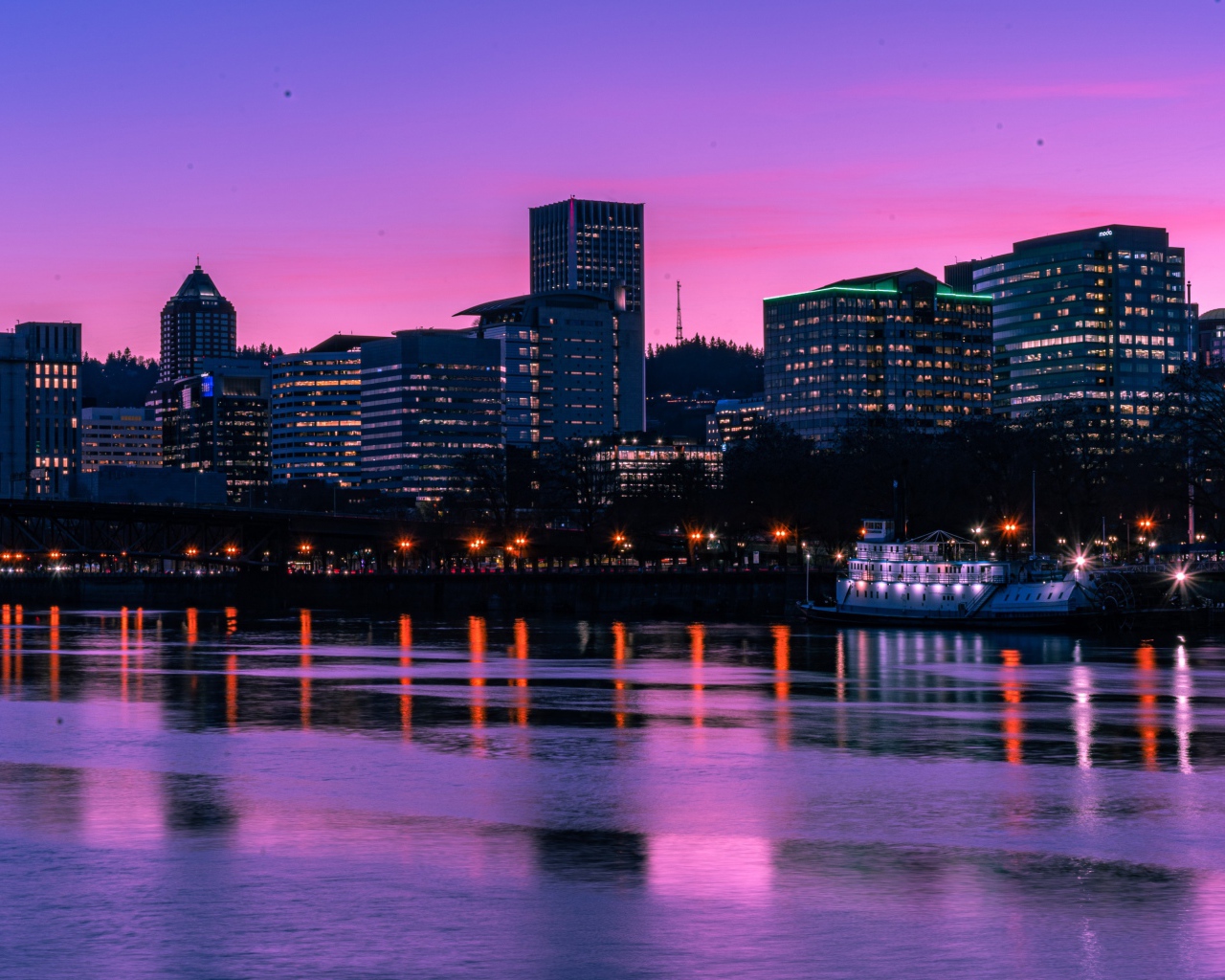 Lilac sunset over the night city by the river