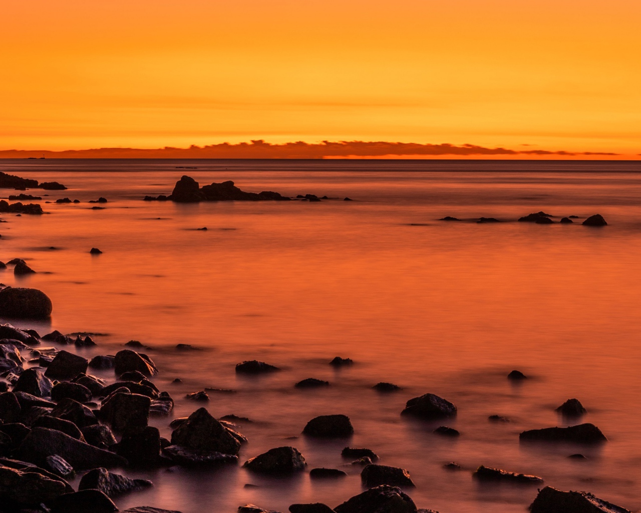 Камни на берегу моря на закате в сумерках 