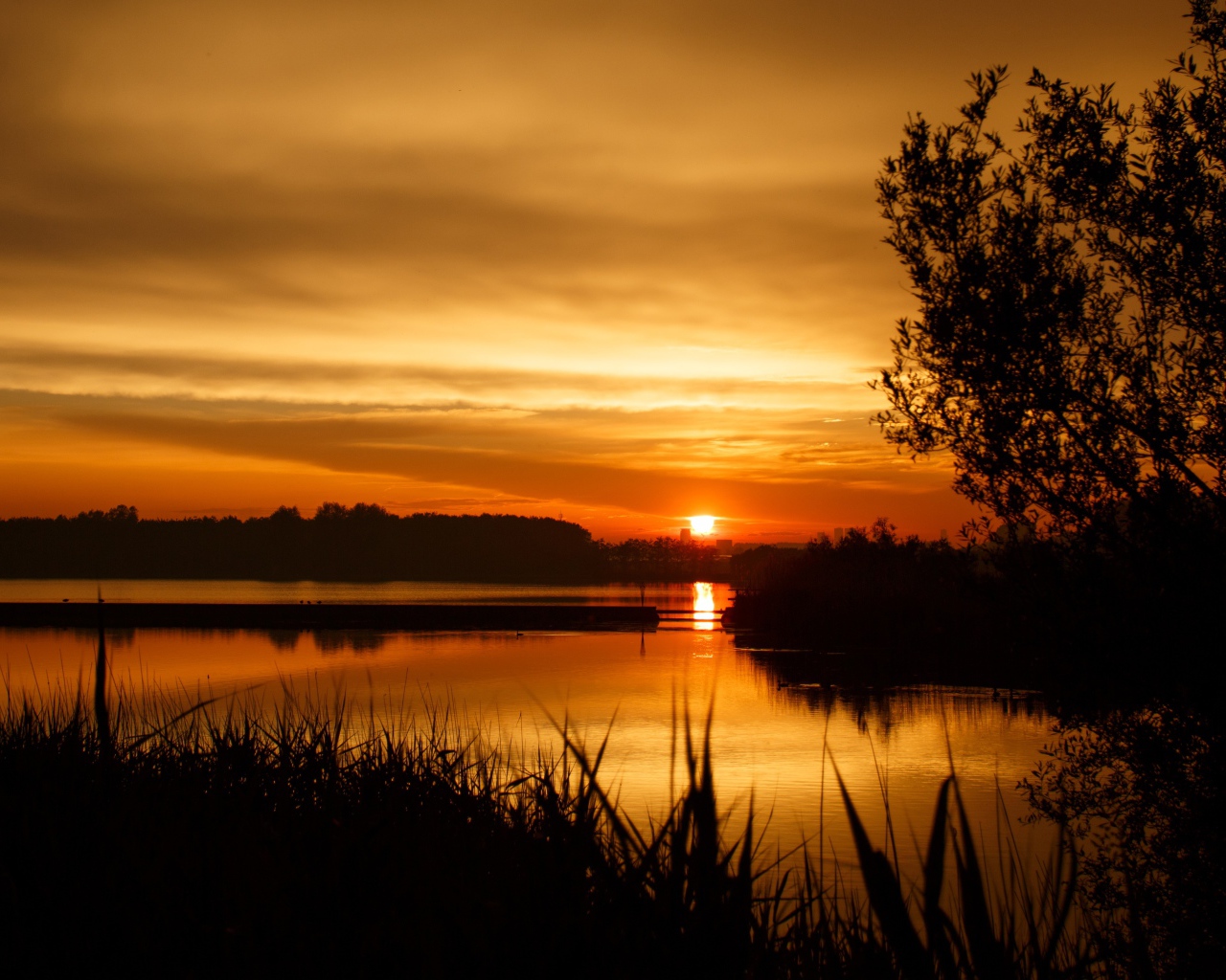 Закат яркого осеннего солнца над рекой 