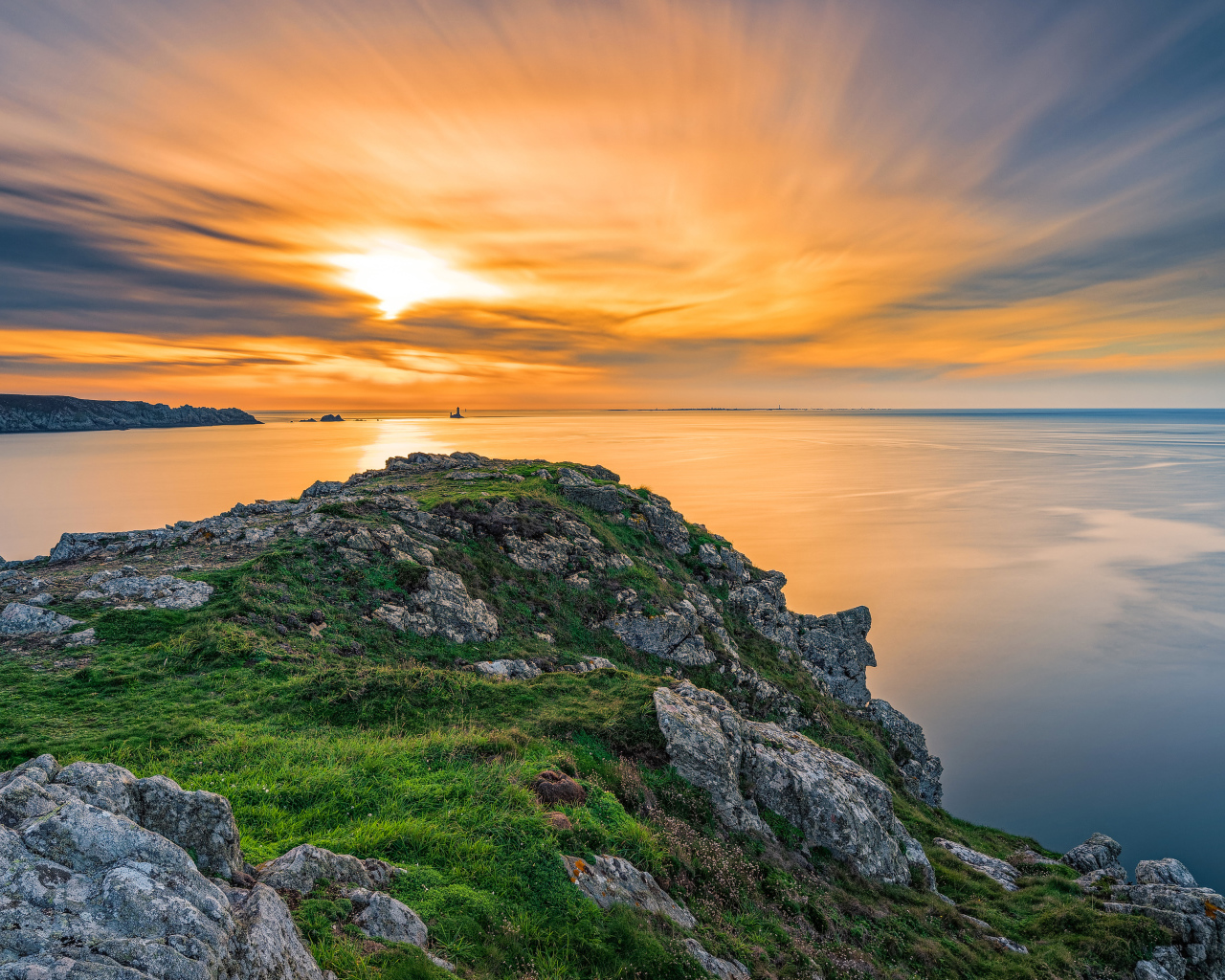 Вид со скалы на красивый закат в небе над спокойным морем 