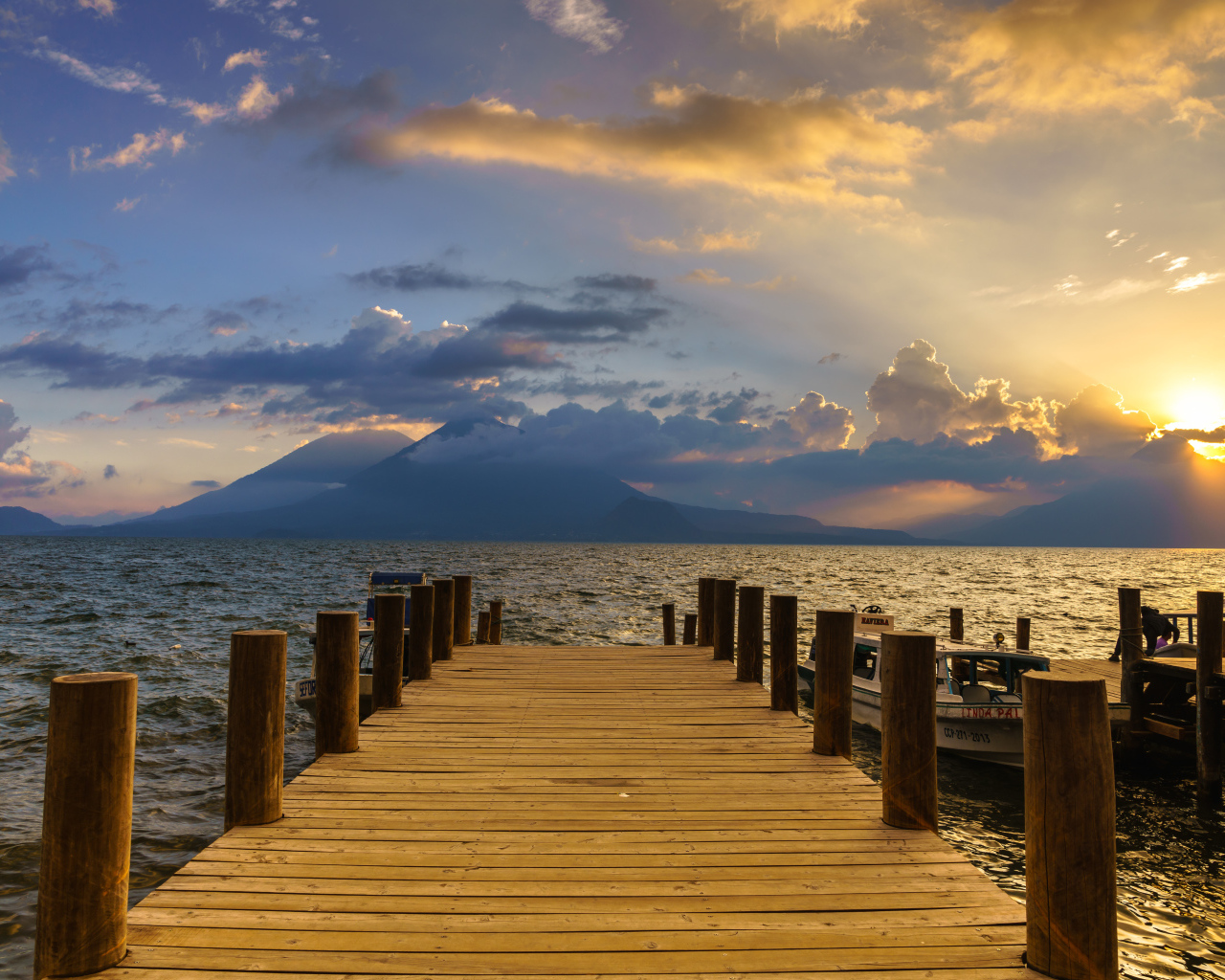 Деревянный мост в море на закате солнца 