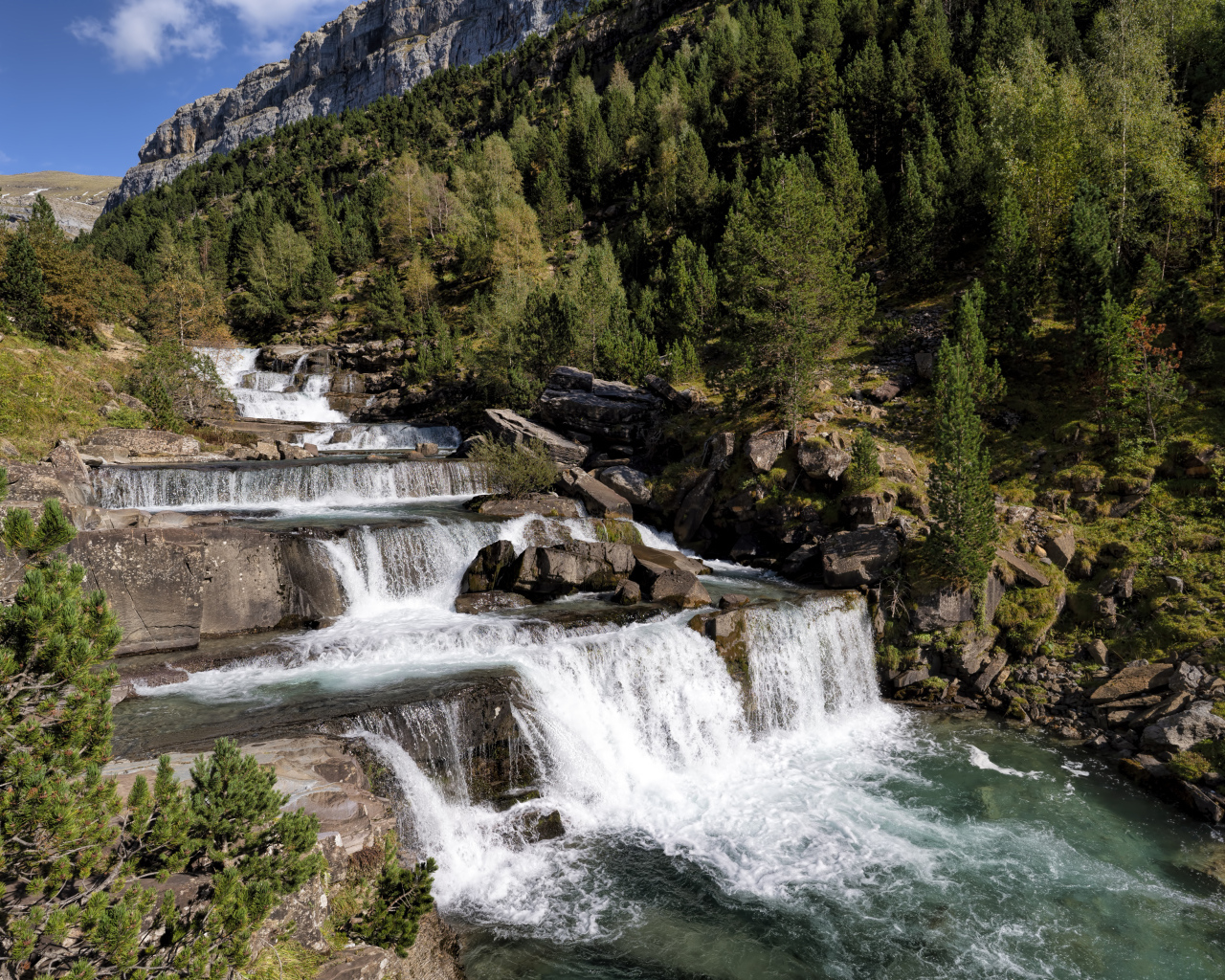 Красивые каскады водопада у скалы 