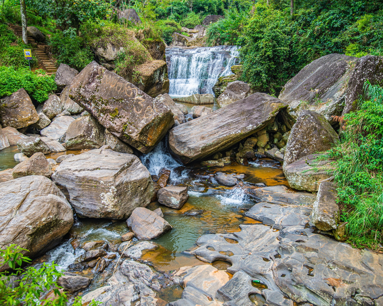 Лесной водопад стекает по огромным камням