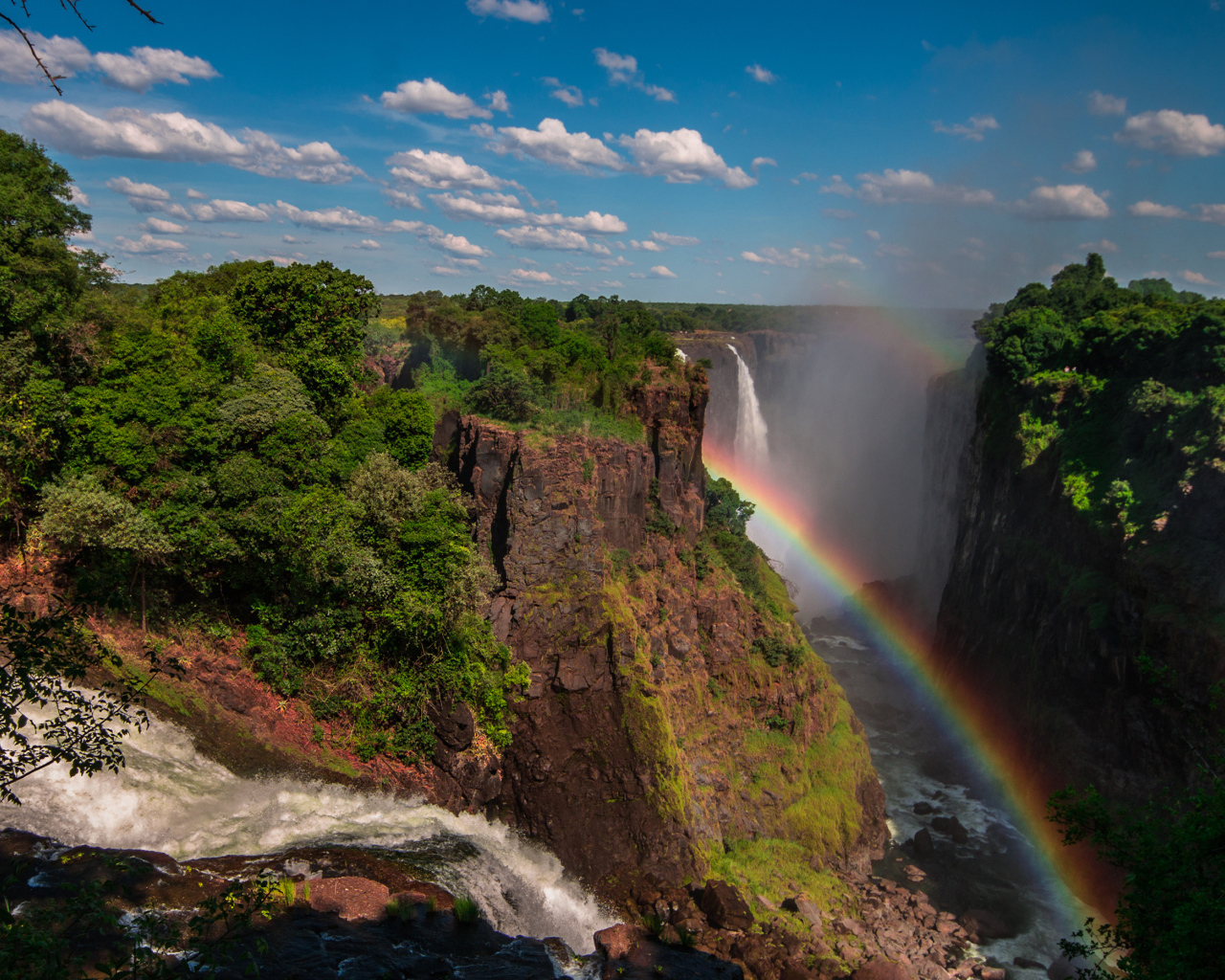 Радуга над водопадом на утесе 
