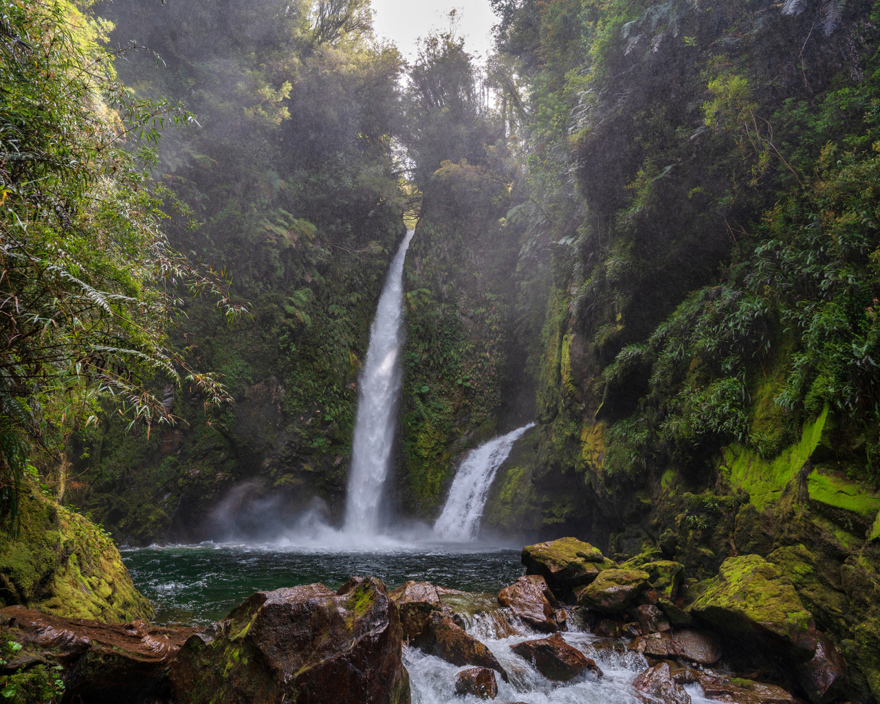 Водопад стекает со скалы в горную реку