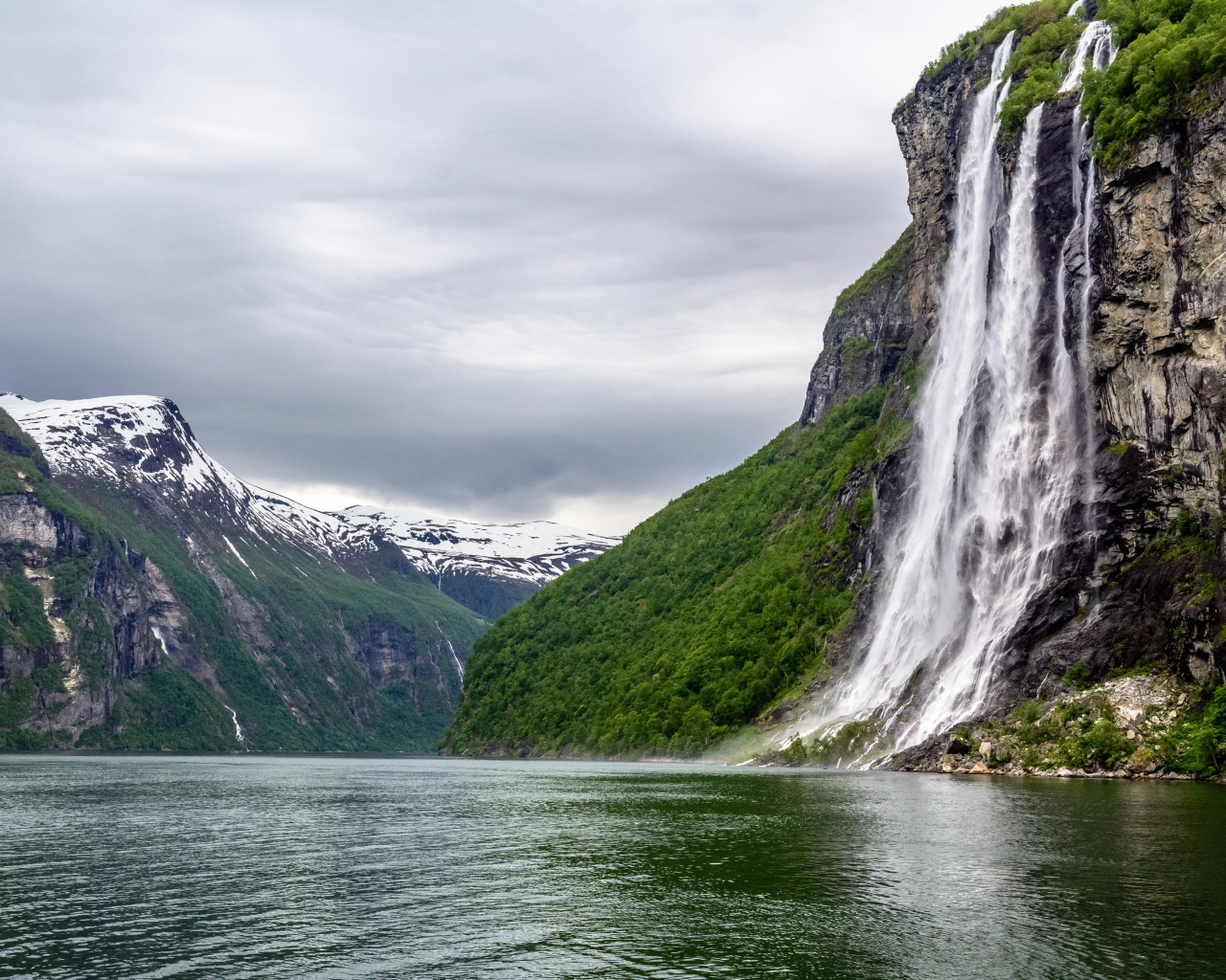 Водопад стекает с утеса в озеро, Норвегия