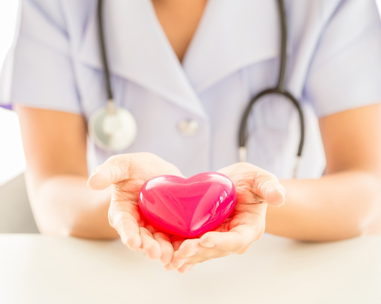 Стеклянное сердце в руках у врача 