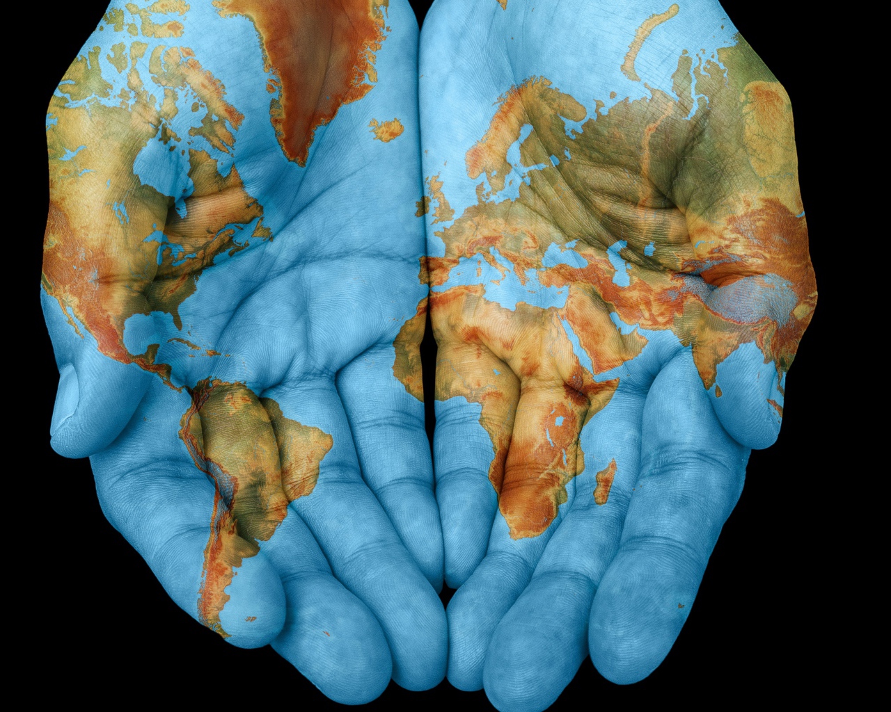 Руки с картой мира на черном фоне 