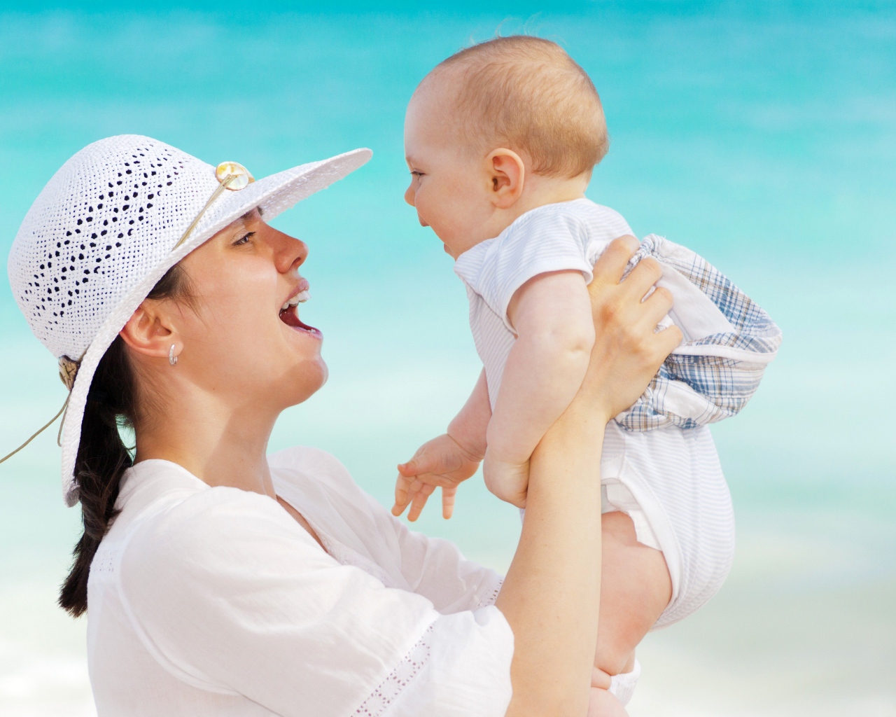 Маленький ребенок на руках у мамы летом