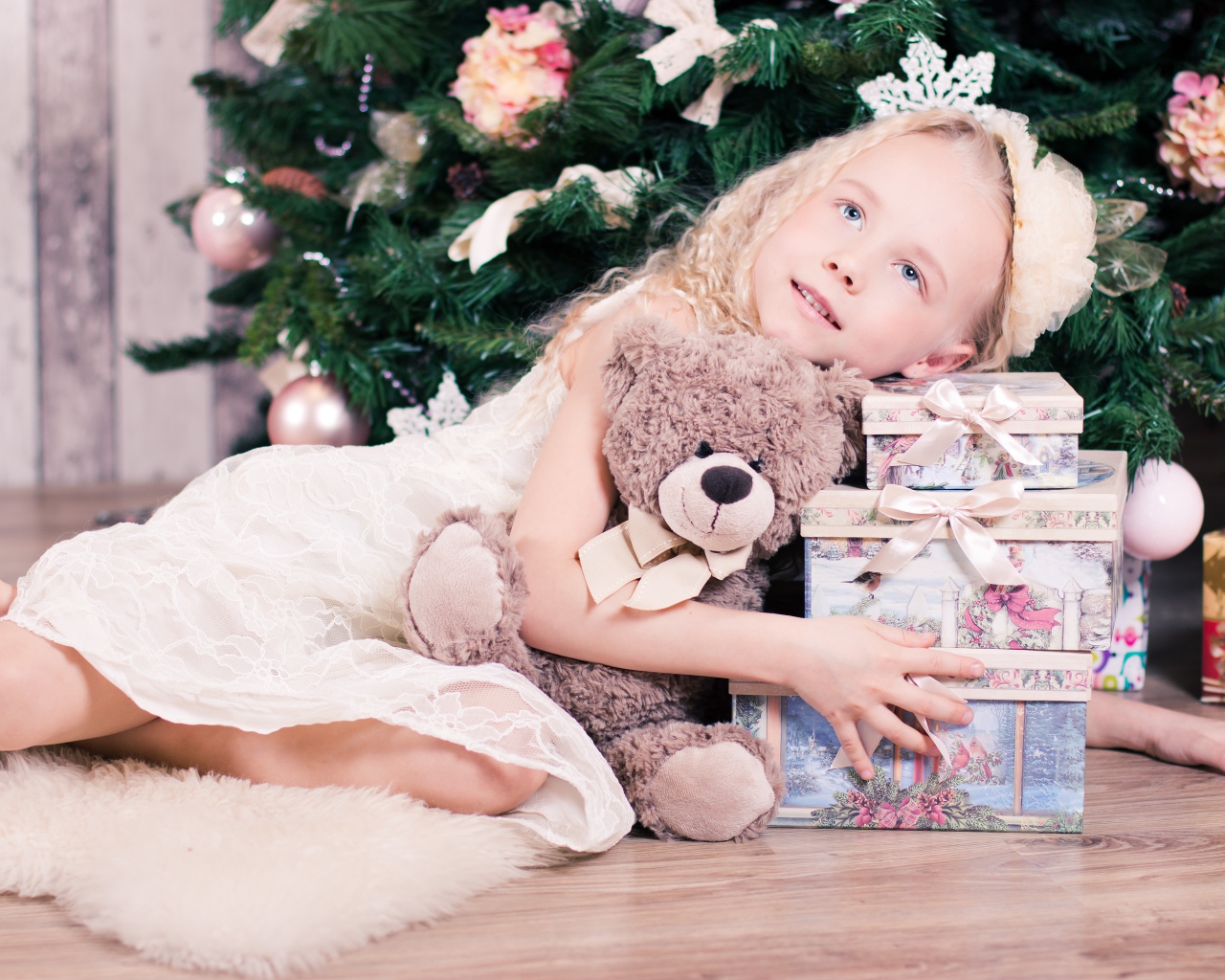 Красивая голубоглазая девочка с подарками у елки