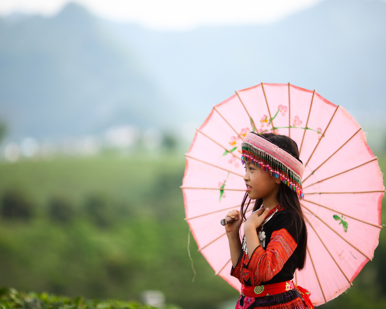 Маленькая девочка азиатка в розовым зонтом