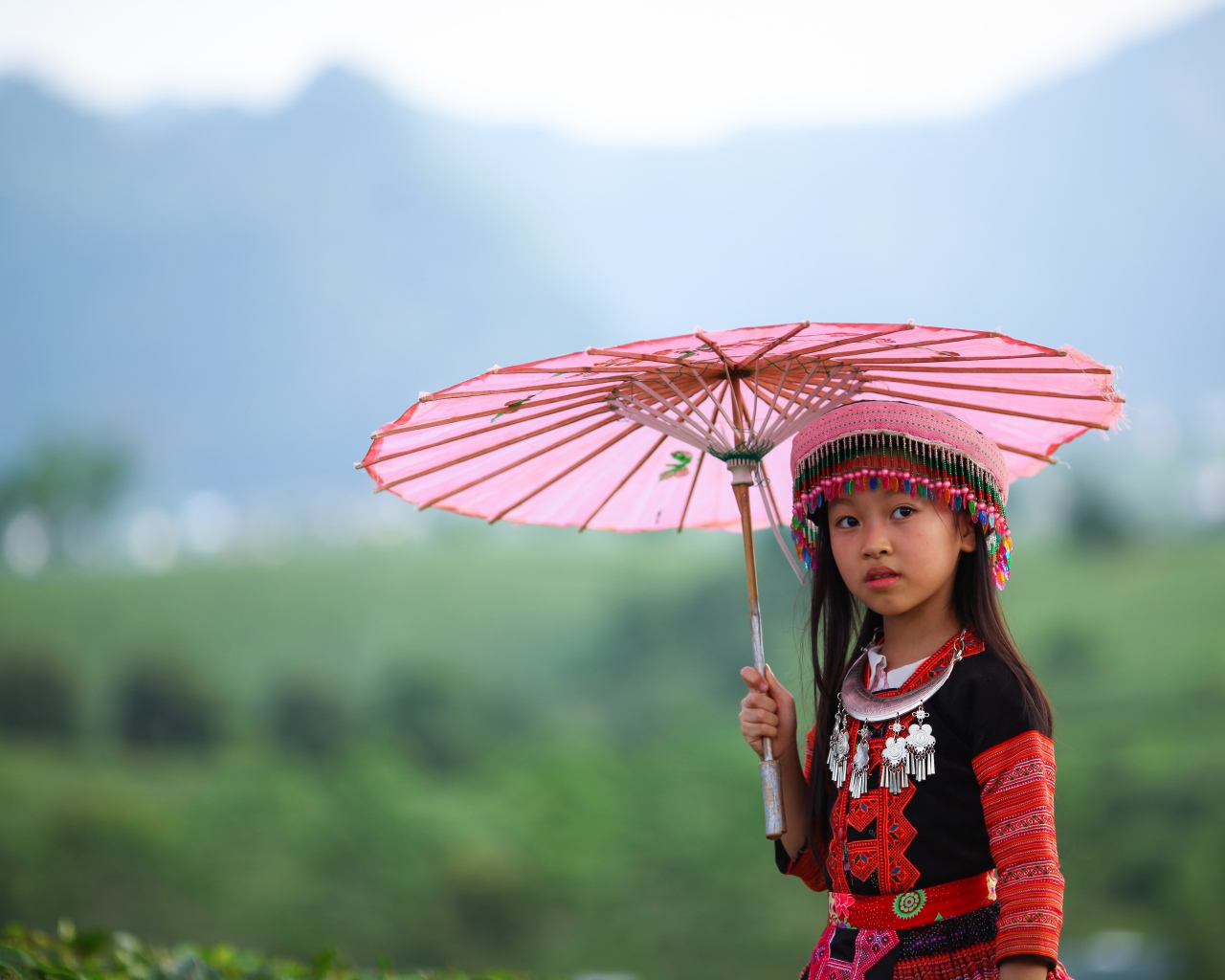 Маленькая девочка азиатка с розовым зонтом