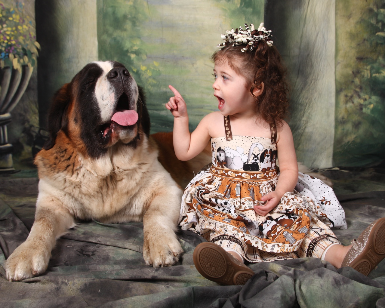 Маленькая красивая девочка с собакой породы сенбернар