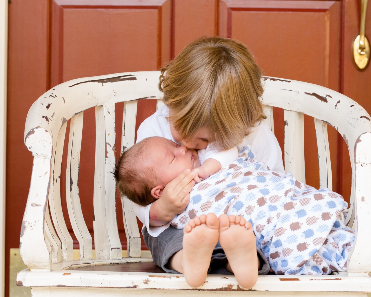 Маленькие мальчик держит брата на руках 