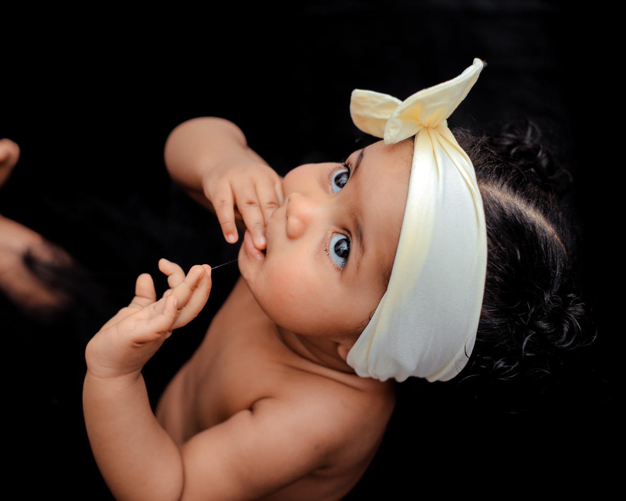 Маленькая темноволосая девочка с бантом на голове 