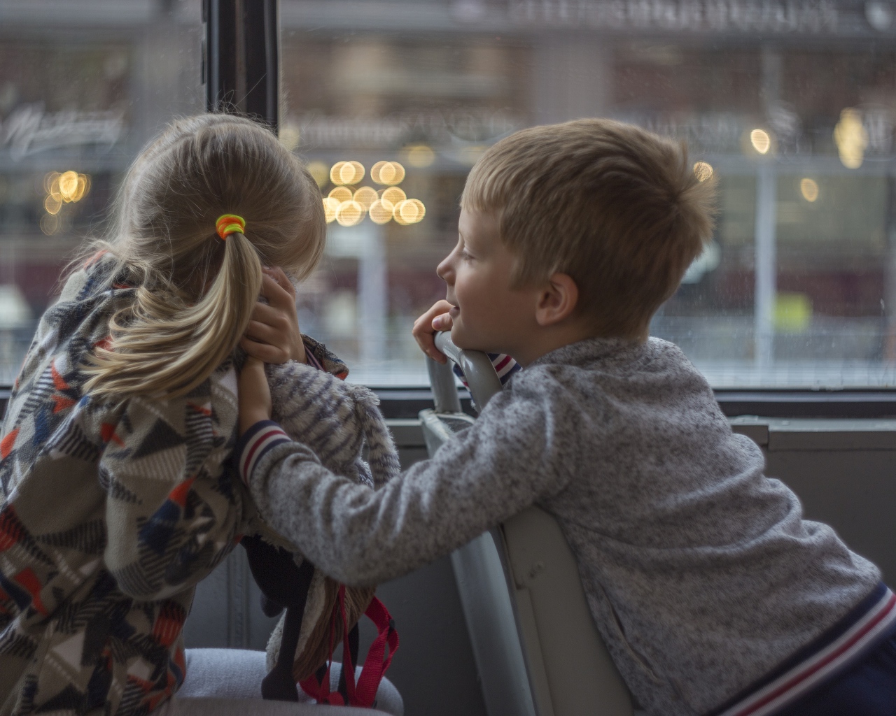 Маленькие девочка и мальчик сидят в автобусе 