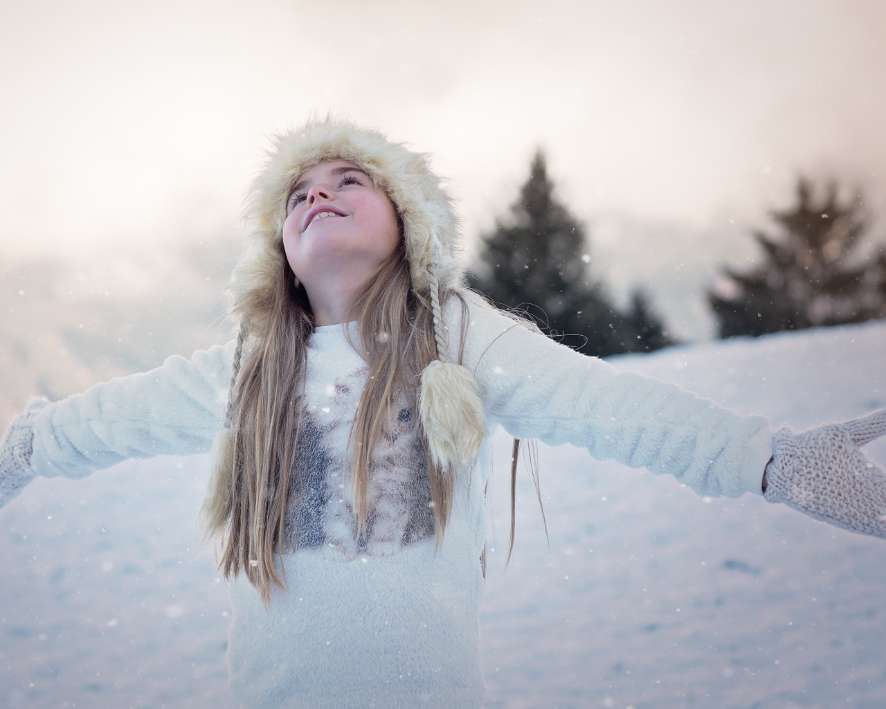 Маленькая девочка в теплой шапке на улице зимой