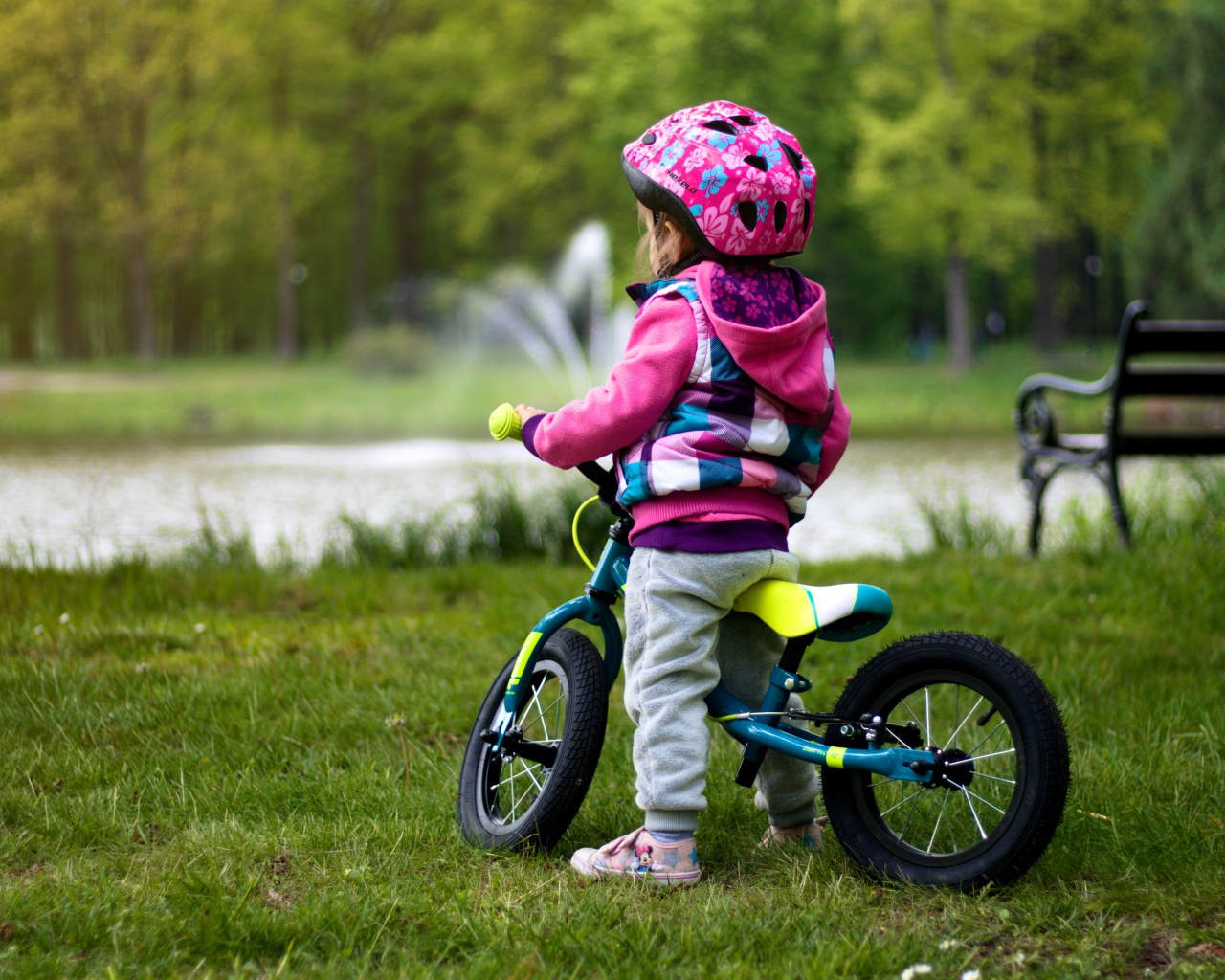 Маленькая девочка на велосипеде в парке 
