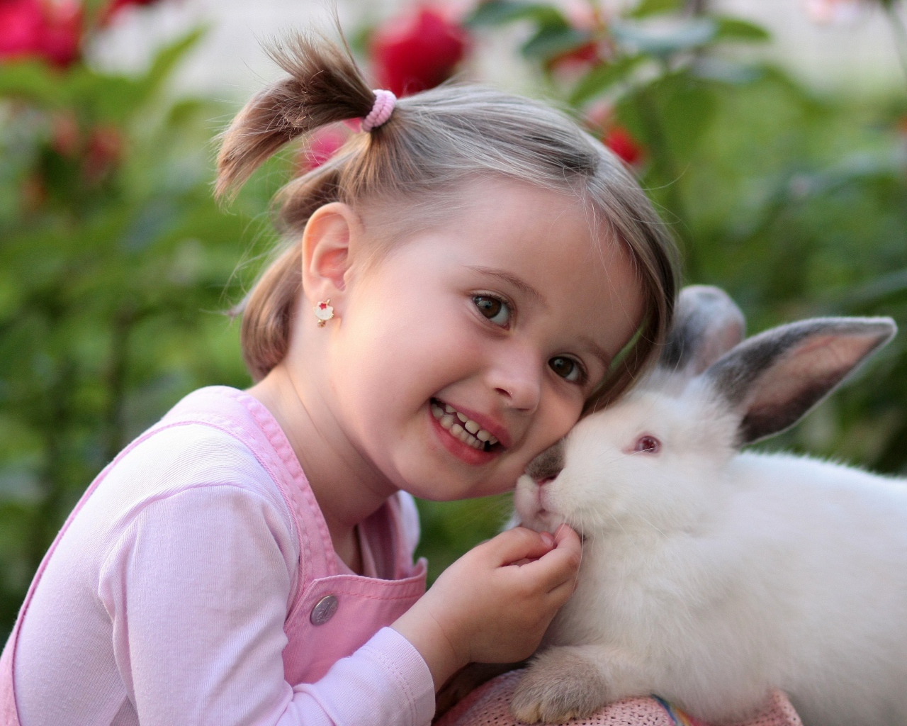 Маленькая улыбающаяся девочка с белым кроликом