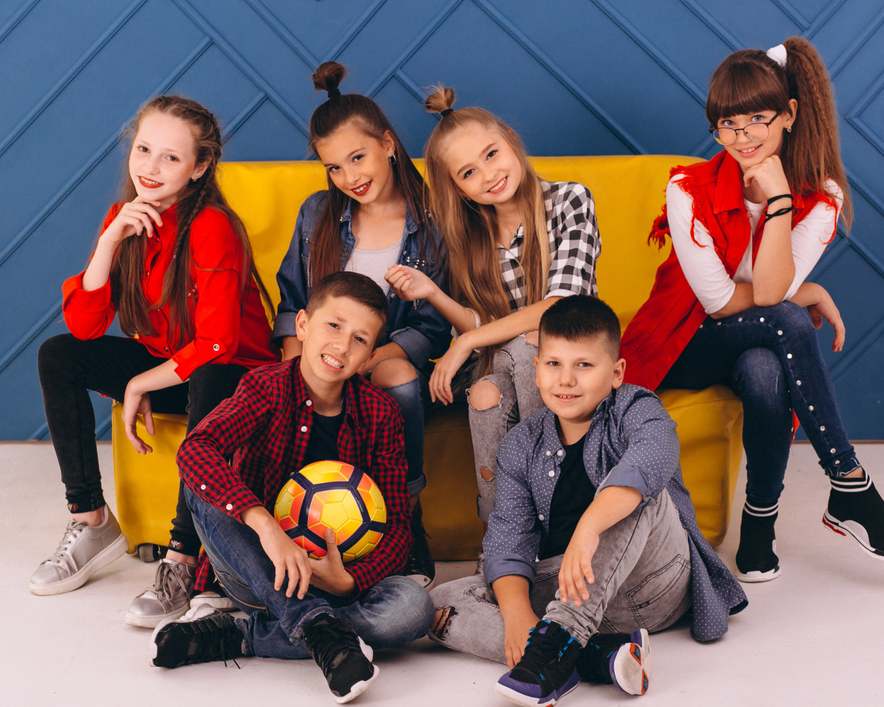 Много модных школьников сидят на диване