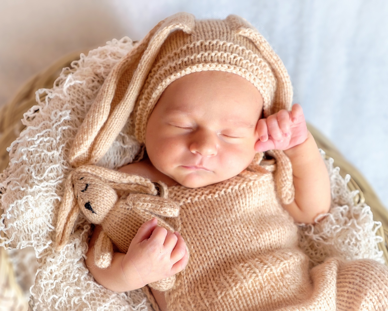 Спящий грудной ребенок в вязаном костюме