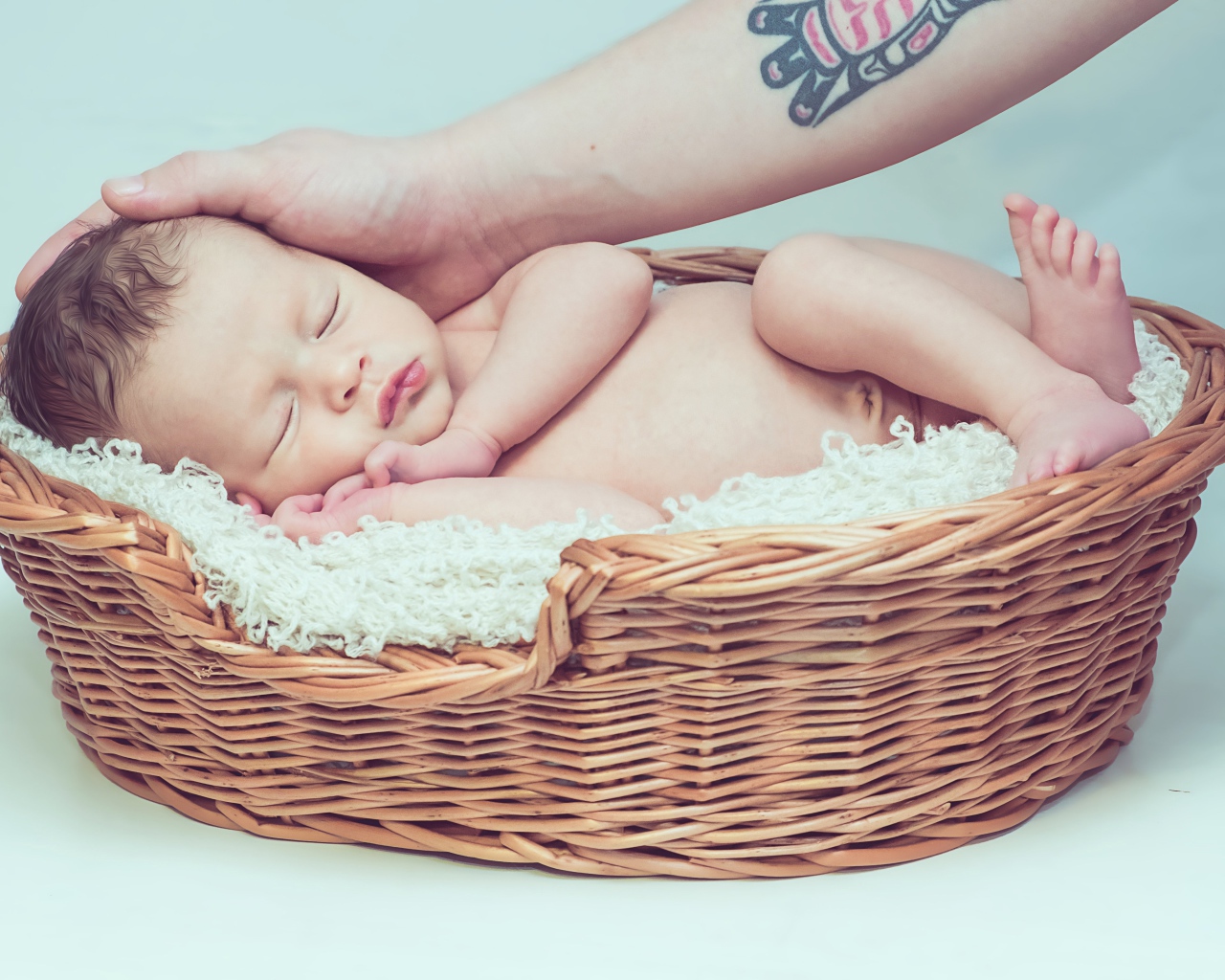 Спящий грудной ребенок в корзине на сером фоне 